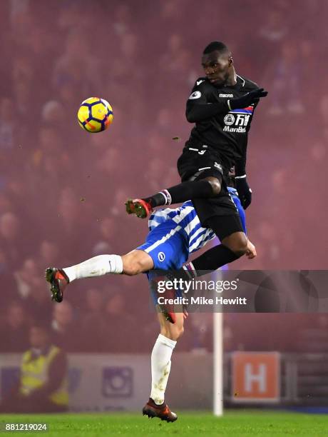 Christian Benteke of Crystal Palace wins a header as a smoke bomb goes off in the away end during the Premier League match between Brighton and Hove...