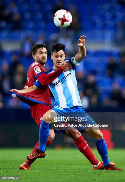Juan Pablo Anor "Juanpi" of Malaga CF duels for the ball with Gregorio Sierra of Numancia during the Copa del Rey match between Malaga CF and...