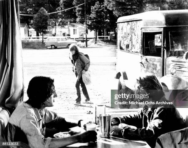 Hitchhiker Laurie Bird slips from a panel truck into the back of their custom 1955 Chevy while driver James Taylor and mechanic Dennis Wilson grab a...