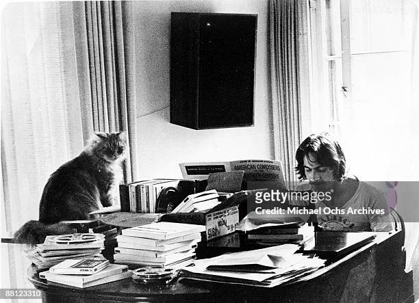 Singer songwriter James Taylor poses for a portrait at a piano piled high with books and a cat named "Pudding" for his manager, record producer...