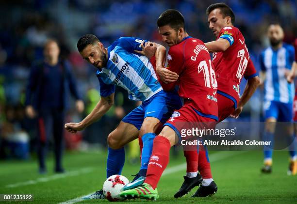 Borja Gonzalez of Malaga CF duels for the ball with Carlos Gutierrez and Luis Valcarce of Numancia during the Copa del Rey match between Malaga CF...