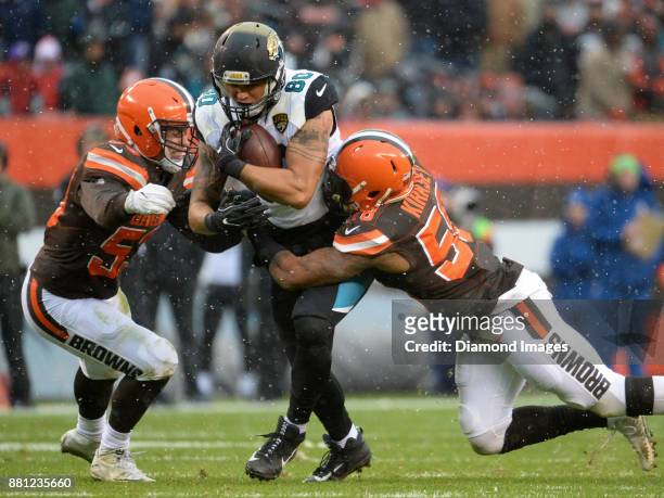 Tight end James O'Shaughnessy of the Jacksonville Jaguars carries the ball downfield as he is tackled by linebackers Joe Schobert and Christian...