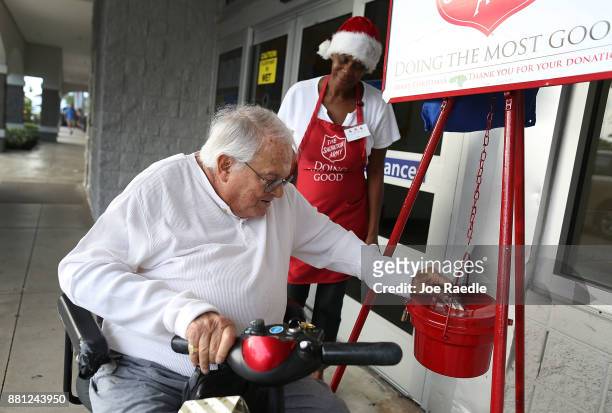 Kim Simmons, a bellringer for the Salvation Army, looks on as Murray Wiseman makes a donation into her red kettle on Giving Tuesday on November 28,...