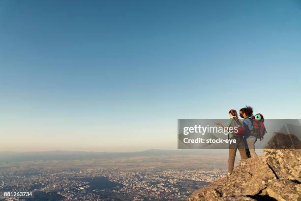 interracial couple on the mountain peak. - falda negra imagens e fotografias de stock