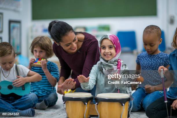 niña tocando tambores - maracas fotografías e imágenes de stock