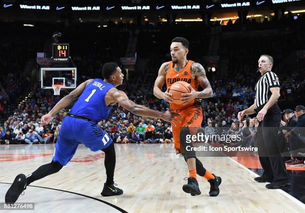 Florida guard Chris Chiozza dribbles by Duke guard Trevon Duval in the championship game of the Motion Bracket at the PK80-Phil Knight Invitational...