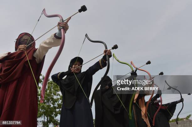 This picture taken on November 12, 2017 shows Indonesian Muslim women participating in an archery lesson in Bekasi. Riding a horse or nailing an...