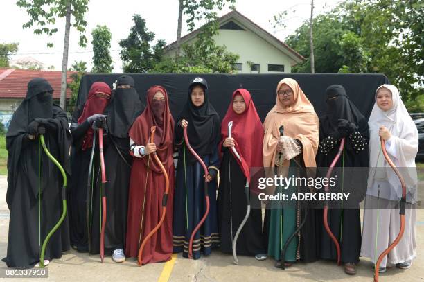 This picture taken on November 12, 2017 shows Indonesian Muslim women posing for a photograph after participating in archery and horse riding lessons...