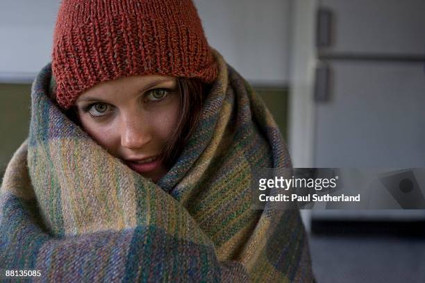 portrait of young woman wrapped in blanket - wrapped in a blanket stockfoto's en -beelden