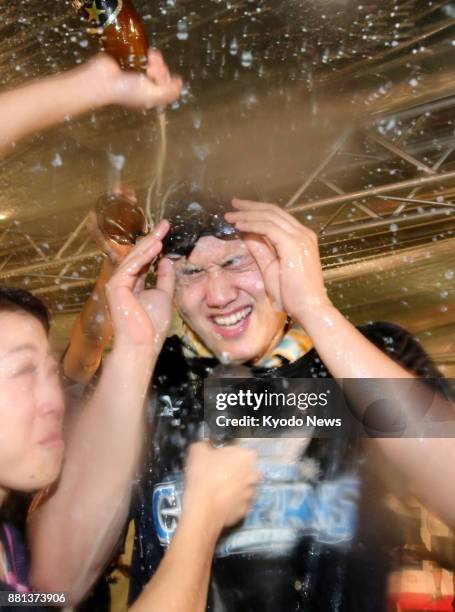 Shohei Otani of the Nippon Ham Fighters is sprayed with beer at a celebration held at a hotel in Hiroshima on Oct. 29 after the team's victory in the...