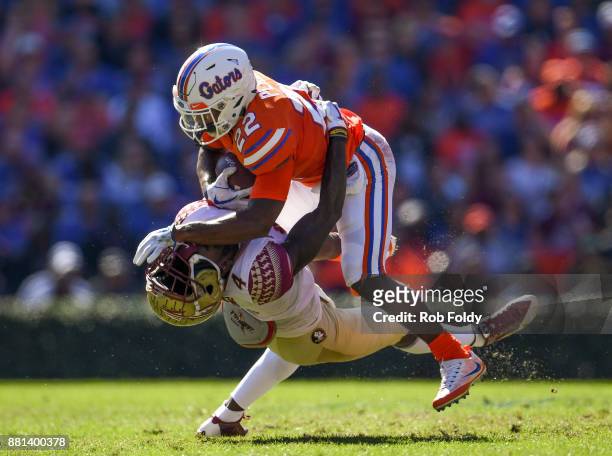 Lamical Perine of the Florida Gators knocks the helmet off of Tarvarus McFadden of the Florida State Seminoles during the game at Ben Hill Griffin...