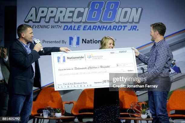 Jim McCoy of Nationwide presents a check to Dale Earnhardt Jr. And his wife Amy to help launch a fund to benefit Nationwide Childrens Hospital during...