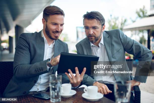 young businessman cooperating with senior colleague outdoors. - business talk stock pictures, royalty-free photos & images