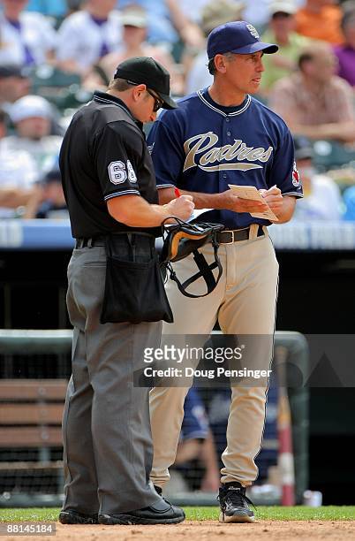Manager Bud Black of the San Diego Padres submits a lineup change with homeplate umpire Chris Guccione against the Colorado Rockies during MLB action...