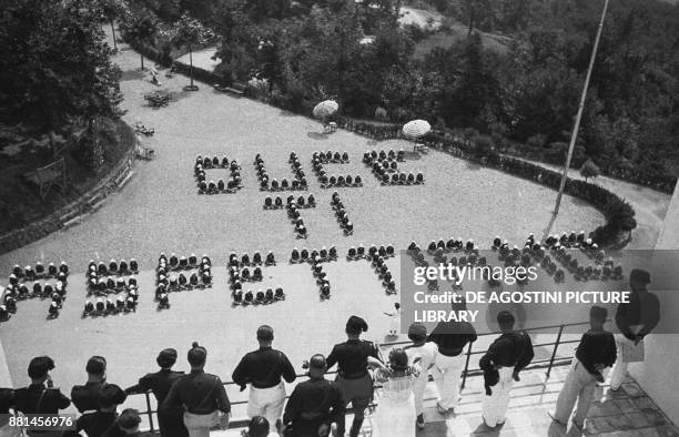 Children at a summer colony arranged to spell the words Duce we await you, 19 July 1937, Genoa, Italy, 20th century.