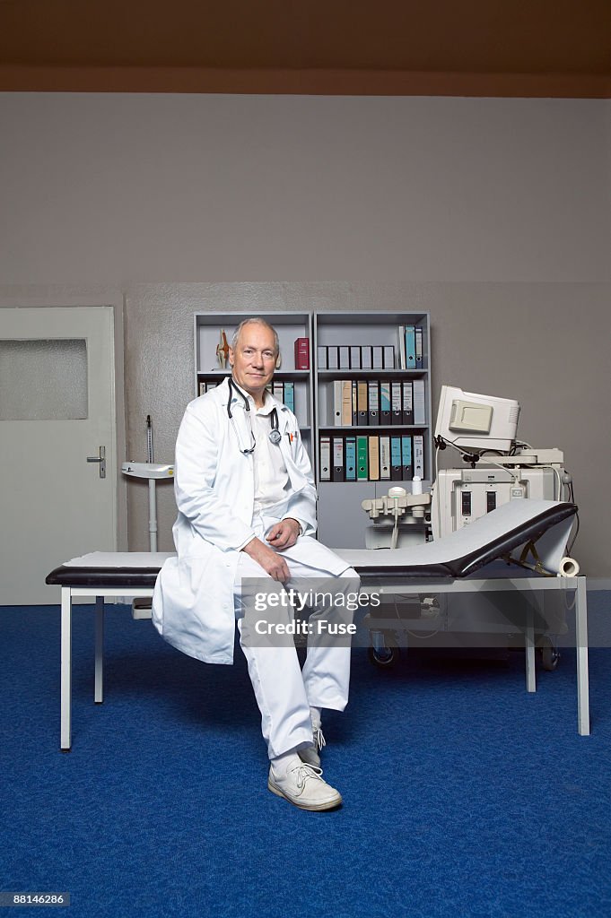 Doctor Sitting on Examination Table