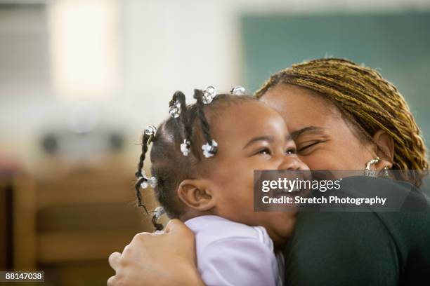 african woman hugging daughter - girl open mouth stockfoto's en -beelden