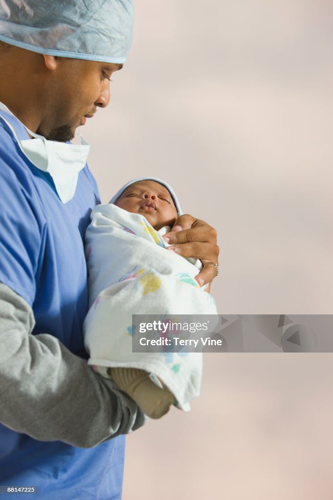 African doctor looking at newborn baby