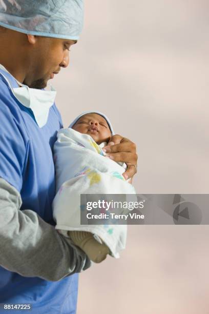 African Doctor Looking At Newborn Baby, Foto de stock