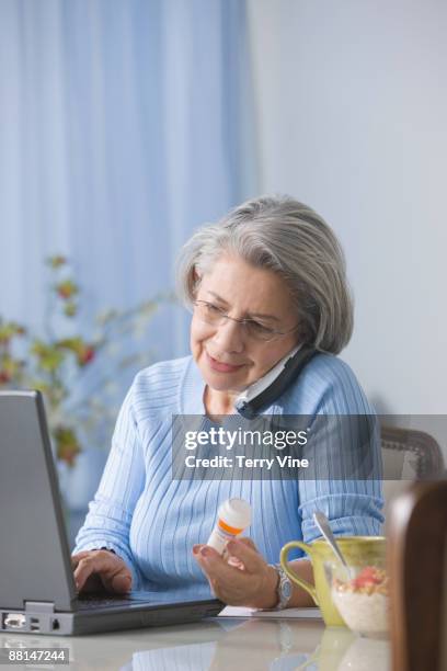 senior hispanic woman refilling drug prescription over the telephone - refill stock pictures, royalty-free photos & images