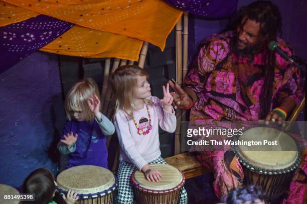 Baba Ras D, the premiere child entertainer in D.C. These days, passes a peace sign to a stage guest during his performance at BloomBars on Saturday,...