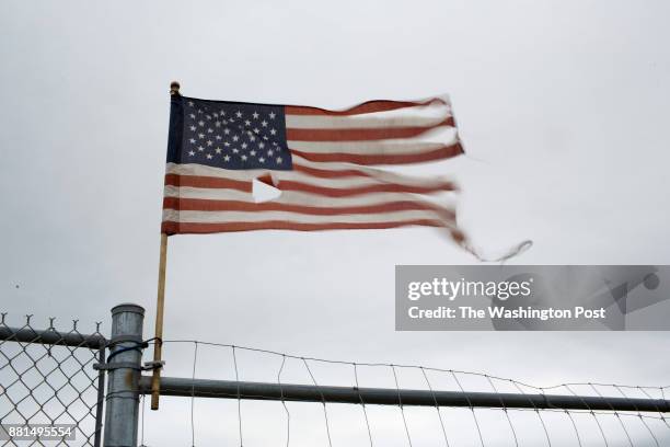 Tattered American flag waving at a work-entrance to the Rockport area airport.