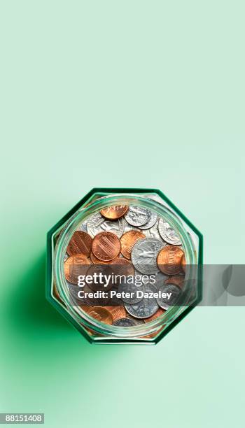 us coins in savings jar. - saving for a rainy day englische redewendung stock-fotos und bilder
