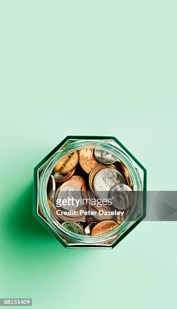 sterling coins in savings jar. - イギリス硬貨 ストックフォトと画像