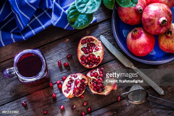 preparing pomegranate juice - food photography dark background blue imagens e fotografias de stock