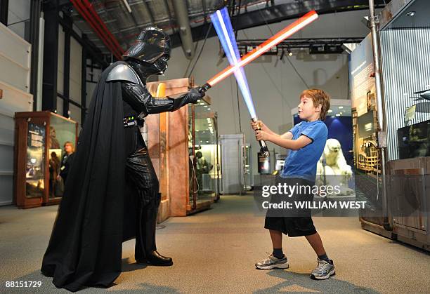 Seven year-old Jet Wigley takes on Darth Vader with a "lightsaber" at the launch of 'Star Wars: Where Science Meets Imagination' exhibition developed...