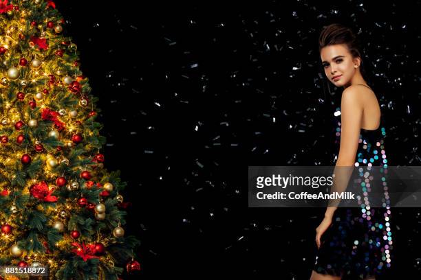 girl in front of christmas tree - christmas party dress stock pictures, royalty-free photos & images