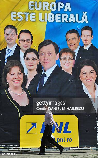 Man walks on June 2, 2009 on a street in Bucharest in front of a billboard of National Liberal Party candidates for the June 7 EU parliamentary...