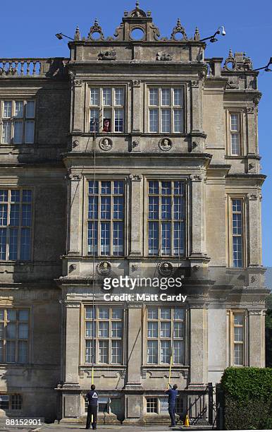 Lord Bath watches from a window of his house as professional window cleaners Nick Walker and Daniel Barr clean the windows at the front of Longleat...