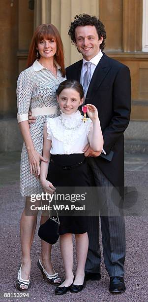 Actor Michael Sheen, daughter Lily and partner Lorraine Stewart with the OBE he received earlier from Queen Elizabeth II during investitures at...