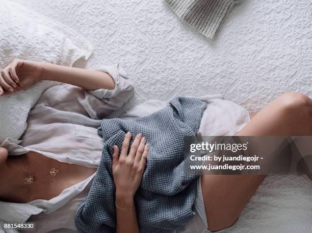 cozy girl lying in bed holding a banket - banket stock-fotos und bilder
