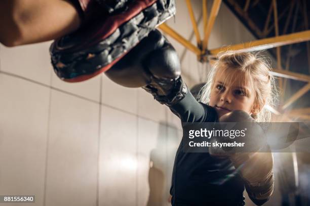 little boxer having a sports training with her unrecognizable coach in a gym. - mixed martial arts stock pictures, royalty-free photos & images