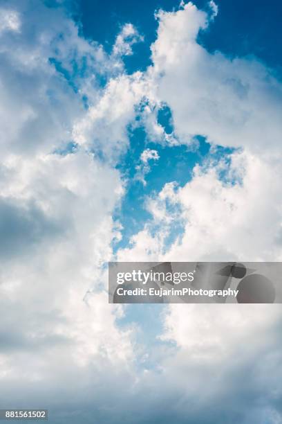 clear blue sky seen between fluffy white clouds - entre deux photos et images de collection