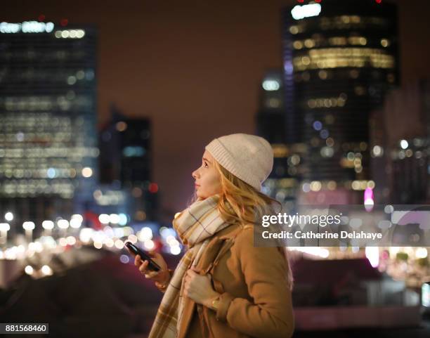 a 17 years old girl with a phone in town by night - 16 17 years girl stock-fotos und bilder