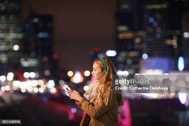 a 17 years old girl with a phone in town by night - 16 17 years imagens e fotografias de stock