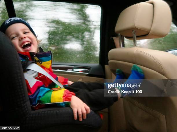 portrait of young child travelling in car safety seat - cool cars foto e immagini stock