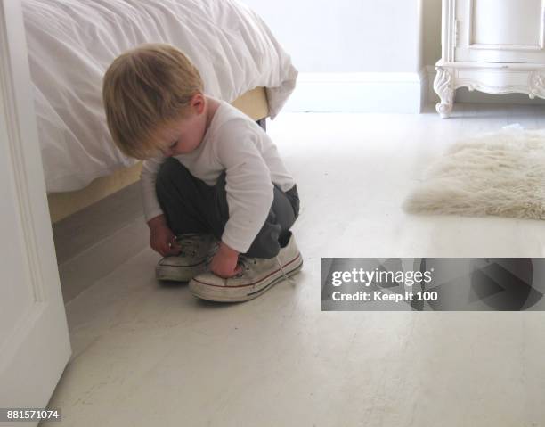 young child trying on adults shoes - too big for bed stock pictures, royalty-free photos & images