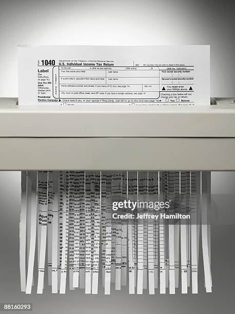 us tax form being shredded. - paper shredder stock pictures, royalty-free photos & images