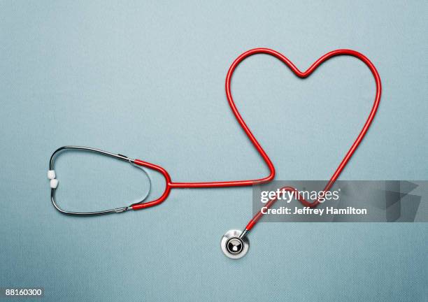 stethoscope forming heart shape - stethoscope heart stock-fotos und bilder