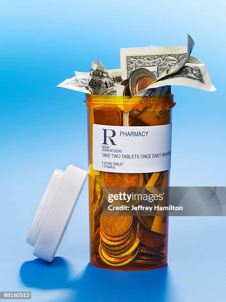 pill bottle full of us coins and dollars - prescription drug costs stock pictures, royalty-free photos & images