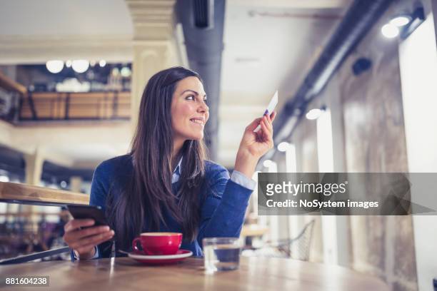 einzelne. junge frauen online-shopping in café, zahlung mit karte - hand of cards stock-fotos und bilder