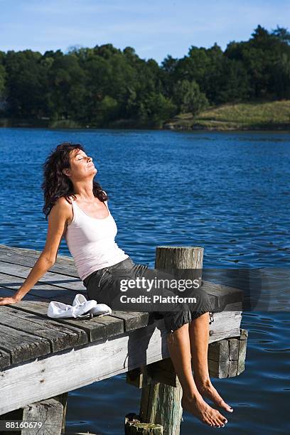 a woman on a jetty by a lake sweden. - jetty stock pictures, royalty-free photos & images