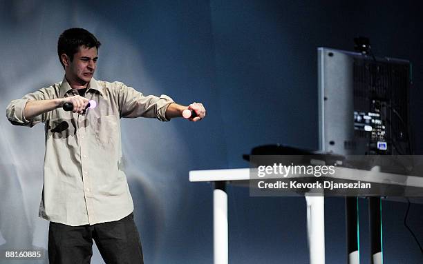 Rick Anton holds two playstation motion controlers during a demonstration at Sony's media breifing at the Electronics and Entertainment Expo on June...