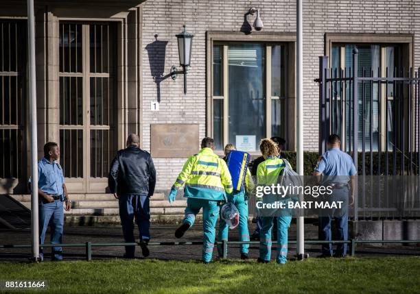 Emergency Services staff walk toward the International Criminal Tribunal for the former Yugoslavia in The Hague, on November 29, 2017. The United...