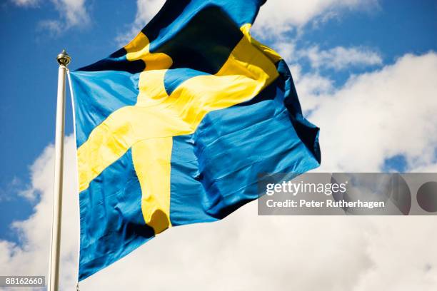 the swedish flag in the wind sweden. - swedish flag stock pictures, royalty-free photos & images