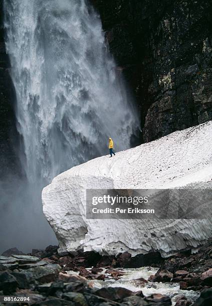 a man by a waterfall njupeskar sweden. - dalarna stock pictures, royalty-free photos & images